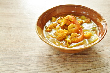 boiled shrimp and mixed vegetable in spicy and sour curry soup or Kang Som Thai food on bowl