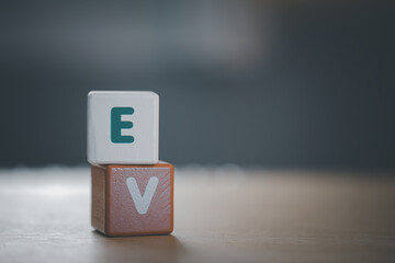 wooden cubes with EV, on blurred nature background means electric car for campaign of save world,...