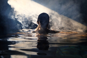 Beautiful woman swims in the pool in the studio.