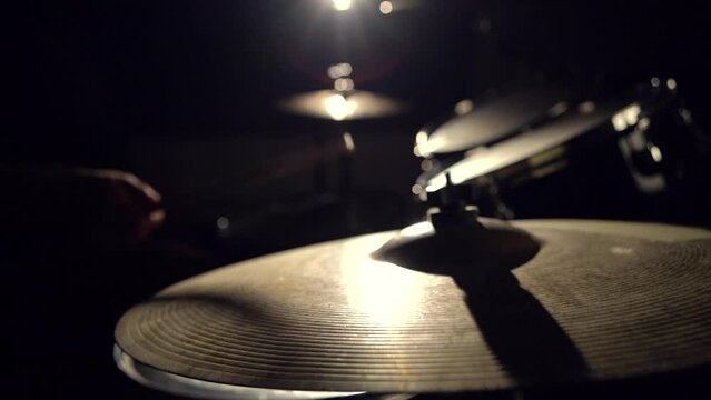 Musician drummer playing hitting drums and cymbals, drumstick close-up view.
