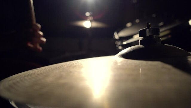 Musician drummer playing hitting drums and cymbals, drumstick close-up view.