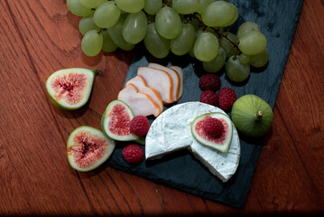 camembert cheese on a metal tray with walnuts and figs