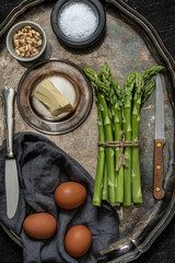 Green asparagus,  eggs, bread, butter, vintage crockery. Top view. Rustic food photography.