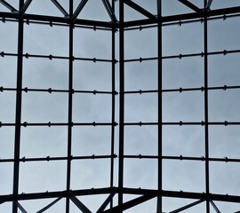 Fondo con detalle de estructura metalica con formas geometricas y cristal, con cielo de fondo