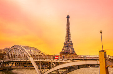 The Eiffel Tower and the arching Pont d'Iéna Bridge at sunrise over the Seine River in Paris, France