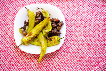 Meat and pepper fry on red table top