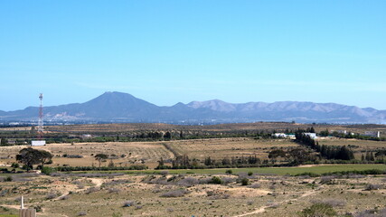 Fields with mountains in the background near the Roman ruins in Uthina, outside of Tunis, Tunisia