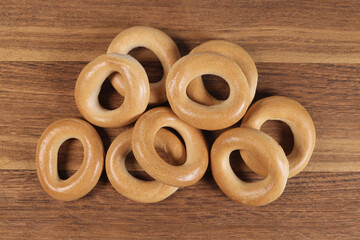 Dry bagels on a wooden background, top view