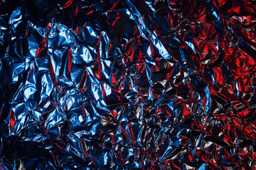 crumpled aluminum foil in red and blue light, background or texture