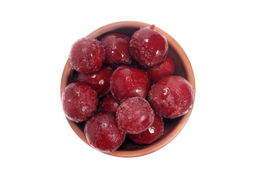 frozen plums in a bowl isolated on white, top view