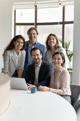 Five millennial and mature businesspeople smiling look at camera pose together in modern office. Executive managers, successful company members, corporate staff portrait. Career, promotion, business