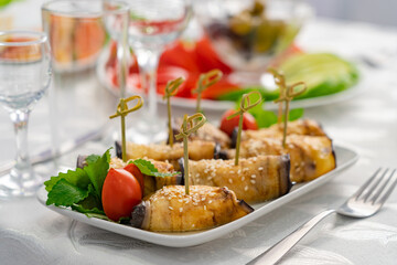 stuffed eggplants and vegetables in a festive table setting with herbs, oranges, lemon and olives
