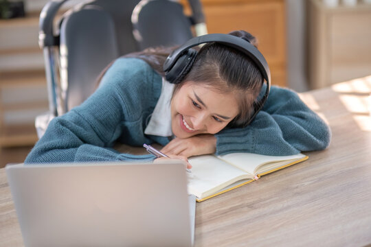 Asian female University student Sleeping on the table Because of tried from studying online at home during self quarantine from the spread of germs, to New normal concept.