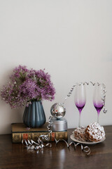 Purple wineglasses on the table with a vase of flowers and finnish traditional funnel cake