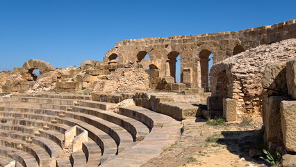 Wall with stone arched windows above the stadium seating in the amphitheater in the Roman ruins at Uthina, outside of Tunis, Tunisia