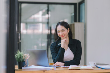 Asian woman thinks and researches using tablet and laptop in startup for management, planning,...