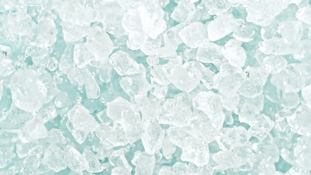 Freeze motion of flying crushed ice isolated on blue background.