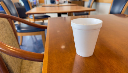 styrofoam cup on the table symbolizes convenience and disposability, but also represents the harmful impact of single-use plastics on the environment