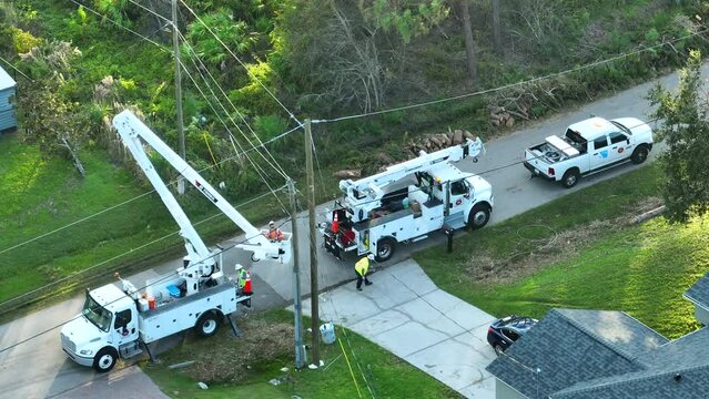 Aerial view of electrician workers repairing damaged power lines after hurricane Ean in Florida suburban area