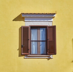 Fototapeta na wymiar Traditional window of Italian house with closing doors in wood.