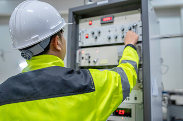 Electrical engineer woman checking voltage at the Power Distribution Cabinet in the control...