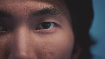 Human eyes of the Asian race. Young beautiful male opens eastern eyes. Extreme close up of an asian man's eyes opening and looking at camera.