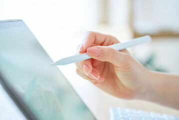 スタイラスペンを持つ女性の手元