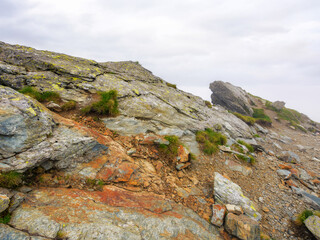 danger and beauty if romanian carpathians. rocky steep slopes in mist. overcast sky