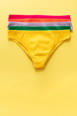 Set of colorful underpants on yellow background, close up