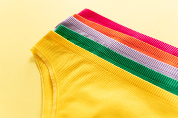 Set of colorful underpants on yellow background, close up