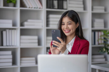 Portrait young asian business woman talk on smartphone write notebook laptop in home office. Beautiful asian girl at desk computer take home order. Startup business asia woman online sme telemarketing