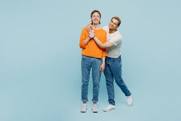 Full body happy young couple two gay men wear casual clothes together hug cuddle looking camera isolated on pastel plain blue color background studio portrait. Pride day june month love LGBTQ concept.