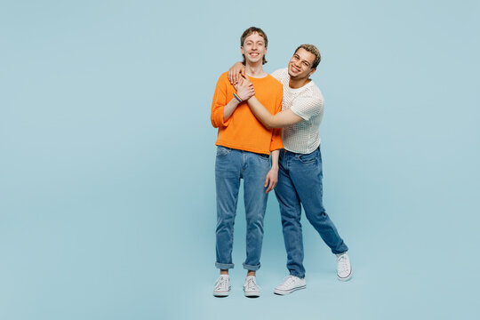 Full body happy young couple two gay men wear casual clothes together hug cuddle looking camera isolated on pastel plain blue color background studio portrait. Pride day june month love LGBTQ concept. - Powered by Adobe