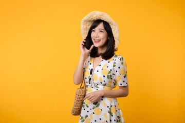 Portrait happy young asian woman with springtime dress fashion using mobile application for advertisement isolated on yellow background. Smartphone app technology concept.