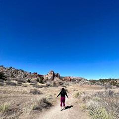 woman on a hiking trail with the garden of the gods park as the landscape background