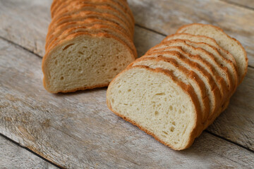 White bread cut into slices on a wooden background