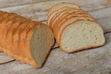 White bread cut into slices on a wooden background
