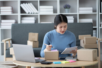 SME businessconcept, young online business shop owner preparing the orders for her customers.
