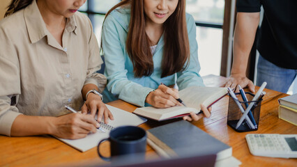 Asian student girl High School Tutor Individual Tuition From Teacher In Library. University Student Tutor books with friends.