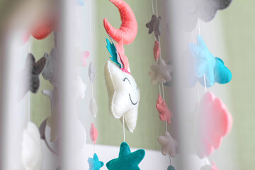 Baby crib mobile with stars, clouds and moon. Kids handmade toys above the newborn crib.