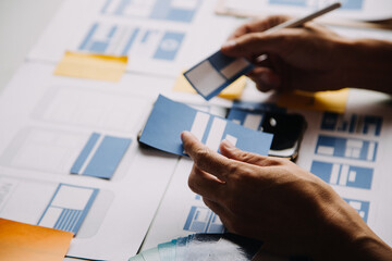 Close up ux developer and ui designer brainstorming about mobile app interface wireframe design on...