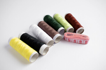 Coloured sewing threads on a white background, top view