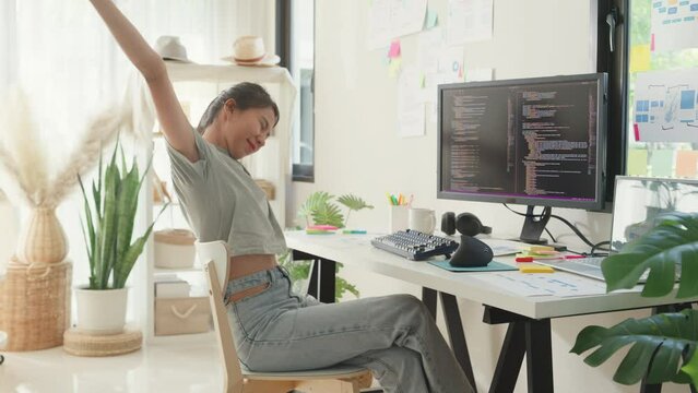 Young Asia girl development programmer overwork relax stretch muscle painful from office syndrome solve problem coding program fix database on computer on table in workplace at house office.
