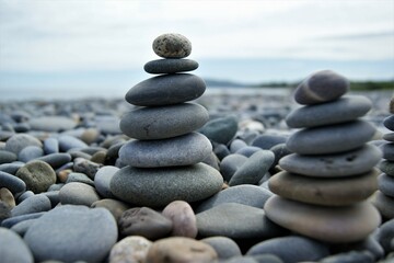 Obraz na płótnie Canvas Towers made of pebbles. Two Zen towers on a rocky beach.