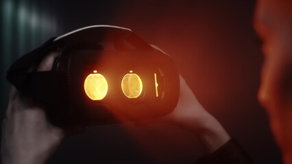 Close-up: A girl puts a virtual reality headset over her eyes. Looks inside the glass of augmented...