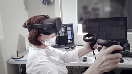 Futuristic Concept: In Medical Laboratory Surgeon Wearing Virtual Reality Headset Uses Controllers...