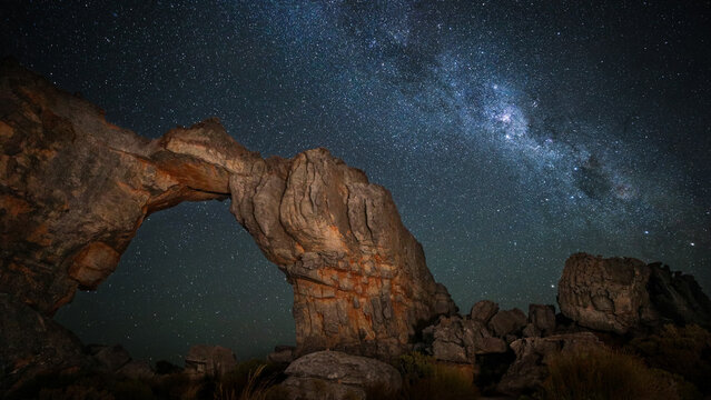 Milky Way galaxy rising in the night sky with rock arch in the foreground, Cederberg Mountains, South Africa
