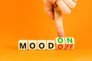 Mood on or off symbol. Businessman turns wooden cubes and changes word Mood off to Mood on. Beautiful orange table orange background. Business and mood on or off concept. Copy space.