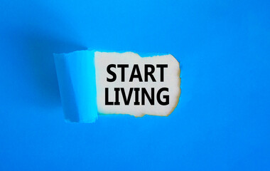 Start living symbol. Concept words Start living on beautiful white paper. Beautiful blue table blue background. Business and Start living concept. Copy space.