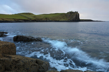 Fototapeta premium Incoming tide at Sunset with Duntulm Castle in the background, Isle of Skye, Scotland, UK.